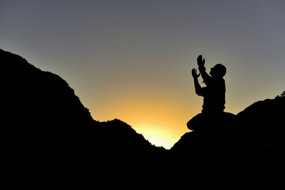 man praying on mountain